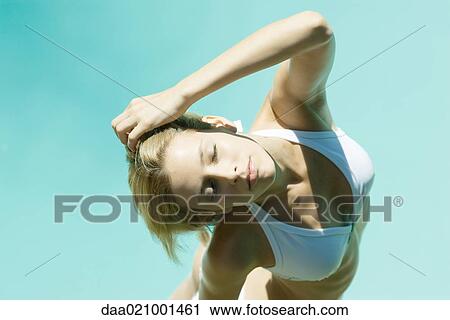 Young woman standing in bikini with hand behind head, eyes closed, high angle view View Large Photo Image Stock Image - Young woman standing in bikini with hand behind head, eyes closed, high angle view. Fotosearch