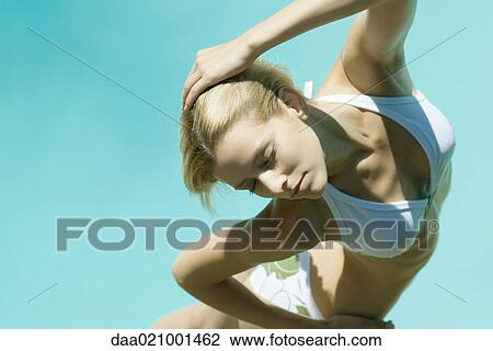 Young woman standing in bikini with hand behind head, eyes closed, high angle view View Large Photo Image Stock Image - Young woman standing in bikini with hand behind head, eyes closed, high angle view. Fotosearch