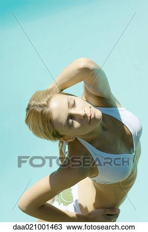 Young woman standing in bikini with hand behind head, eyes closed, high angle view View Large Photo Image Stock Image - Young woman standing in bikini with hand behind head, eyes closed, high angle view. Fotosearch