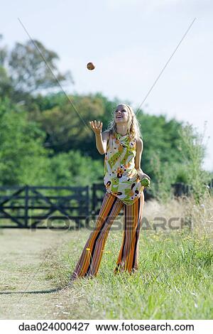 Young woman standing in field, juggling apples View Large Photo Image Stock Photo - Young woman standing in field, juggling apples. Fotosearch