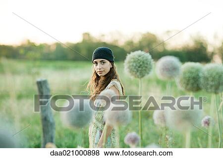 Stock Photo - Young woman standing in field. Fotosearch