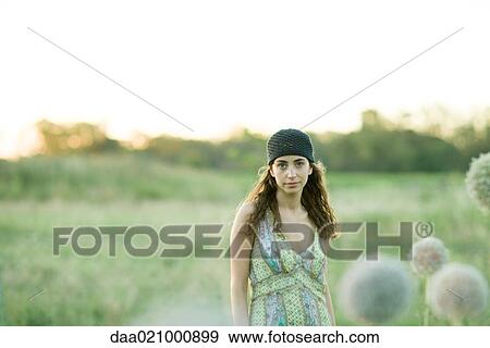 Stock Photo - Young woman standing in field. Fotosearch