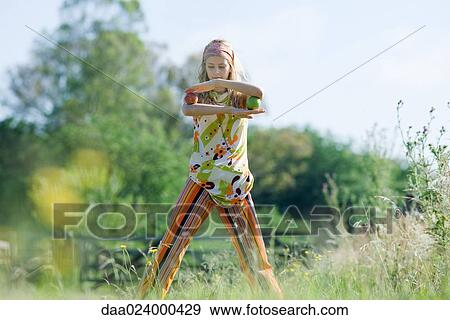 Young woman standing in field, balancing apples on elbows View Large Photo Image Stock Photo - Young woman standing in field, balancing apples on elbows. Fotosearch