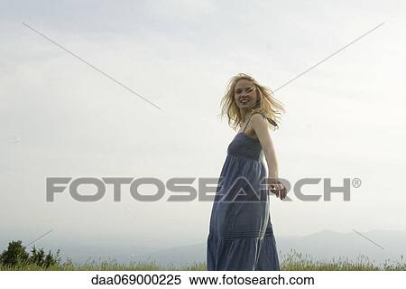 Young woman standing in meadow on breezy day, bubbles floating around her View Large Photo Image Stock Photography - Young woman standing in meadow on breezy day, bubbles floating around her. Fotosearch