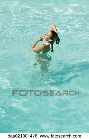 Young woman standing in pool, hand behind head, full length, high angle view View Large Photo Image Stock Photo - Young woman standing in pool, hand behind head, full length, high angle view. Fotosearch