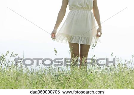Young woman standing in tall grass, cropped View Large Photo Image Stock Photography - Young woman standing in tall grass, cropped. Fotosearch