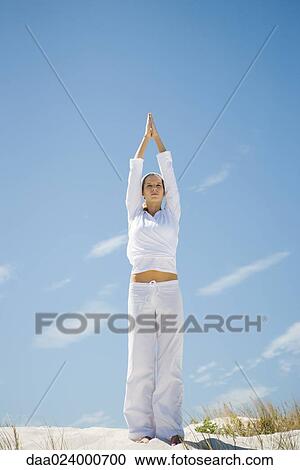 Young woman standing on dune, exercising View Large Photo Image Stock Image - Young woman standing on dune, exercising. Fotosearch