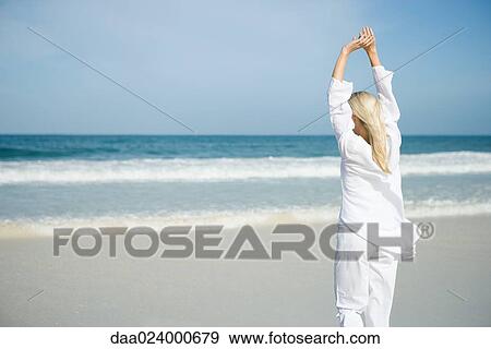 Young woman stretching on beach, rear view View Large Photo Image Stock Photo - Young woman stretching on beach, rear view. Fotosearch