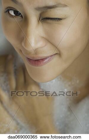 Young woman taking bubble bath, winking, high angle view View Large Photo Image Stock Photography - Young woman taking bubble bath, winking, high angle view. Fotosearch