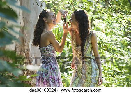 Stock Photo - Young woman taking photograph for friend. Fotosearch