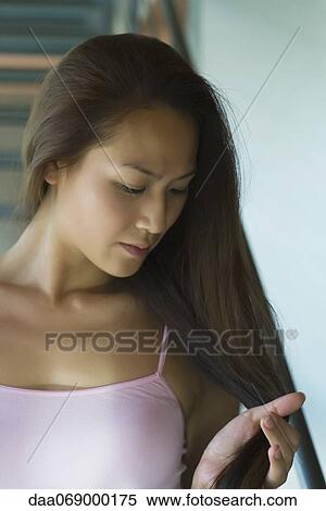 Young woman touching hair View Large Photo Image Stock Photography - Young woman touching hair. Fotosearch