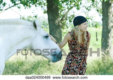 Young woman touching horse and laughing View Large Photo Image Stock Photo - Young woman touching horse and laughing. Fotosearch