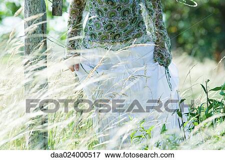 Young woman walking in rural field, cropped view View Large Photo Image Stock Photo - Young woman walking in rural field, cropped view. Fotosearch