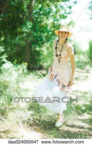 Young woman walking in woods, smiling at camera View Large Photo Image Stock Photo - Young woman walking in woods, smiling at camera. Fotosearch