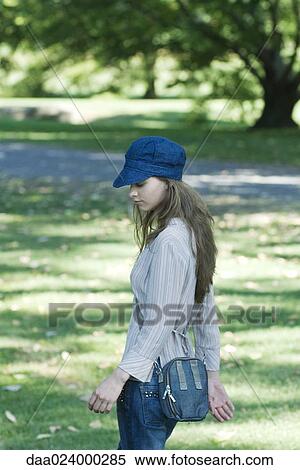 Stock Photography - Young woman walking through park. Fotosearch