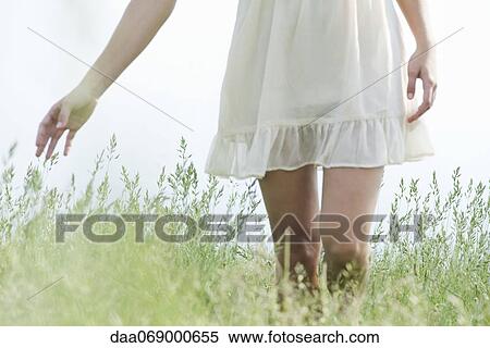 Young woman walking through tall grass, cropped View Large Photo Image Stock Photography - Young woman walking through tall grass, cropped. Fotosearch