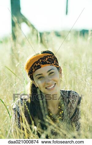 Young woman wearing scarf around head, in field, portrait View Large Photo Image Picture - Young woman wearing scarf around head, in field, portrait. Fotosearch