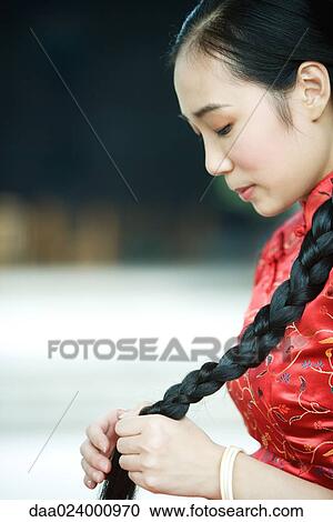 Young woman wearing traditional Chinese clothing, holding long braid View Large Photo Image Stock Image - Young woman wearing traditional Chinese clothing, holding long braid. Fotosearch
