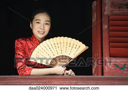 Young woman wearing traditional Chinese clothing, holding fan View Large Photo Image Stock Image - Young woman wearing traditional Chinese clothing, holding fan. Fotosearch