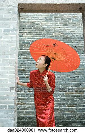 Young woman wearing traditional Chinese clothing, holding parasol, looking up through doorway View Large Photo Image Stock Image - Young woman wearing traditional Chinese clothing, holding parasol, looking up through doorway. Fotosearch