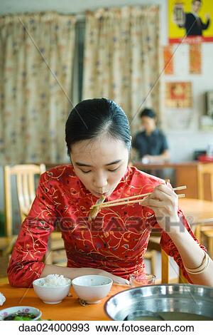 Young woman wearing traditional Chinese clothing, eating with chopsticks View Large Photo Image Stock Image - Young woman wearing traditional Chinese clothing, eating with chopsticks. Fotosearch
