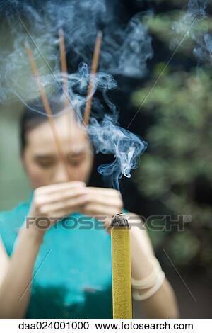 Young woman wearing traditional Chinese clothing, holding up incense View Large Photo Image Stock Image - Young woman wearing traditional Chinese clothing, holding up incense. Fotosearch