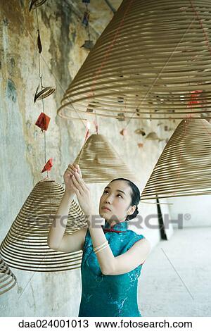 Young woman wearing traditional Chinese clothing, lighting spiral of incense View Large Photo Image Stock Image - Young woman wearing traditional Chinese clothing, lighting spiral of incense. Fotosearch