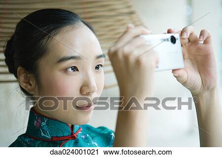 Young woman wearing traditional Chinese clothing, taking photo with digital camera View Large Photo Image Stock Image - Young woman wearing traditional Chinese clothing, taking photo with digital camera. Fotosearch
