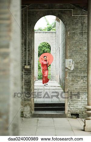 Young woman wearing traditional Chinese clothing, walking with parasol View Large Photo Image Stock Photo - Young woman wearing traditional Chinese clothing, walking with parasol. Fotosearch