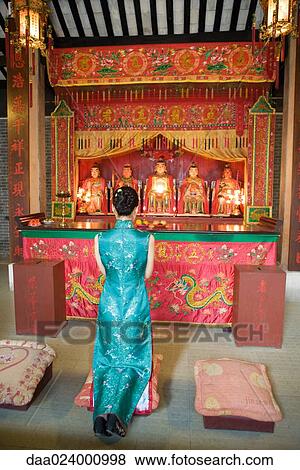Young woman wearing traditional Chinese clothing, kneeling in front of shrine View Large Photo Image Stock Photo - Young woman wearing traditional Chinese clothing, kneeling in front of shrine. Fotosearch