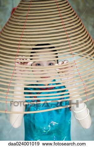 Young woman wearing traditional Chinese clothing, looking through spiral of incense View Large Photo Image Stock Photo - Young woman wearing traditional Chinese clothing, looking through spiral of incense. Fotosearch