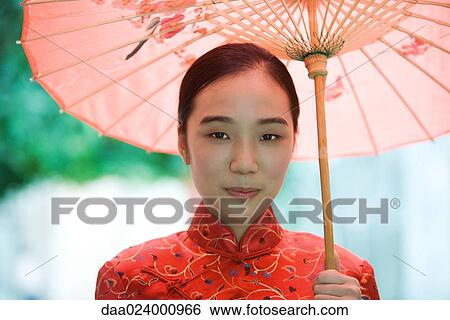 Young woman wearing traditional Chinese clothing, holding parasol View Large Photo Image Stock Photograph - Young woman wearing traditional Chinese clothing, holding parasol. Fotosearch
