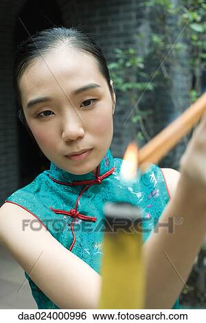 Young woman wearing traditional Chinese clothing, lighting incense View Large Photo Image Stock Photograph - Young woman wearing traditional Chinese clothing, lighting incense. Fotosearch