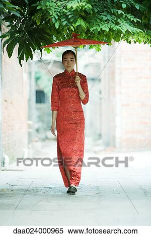 Young woman wearing traditional Chinese clothing, walking with parasol View Large Photo Image Stock Photography - Young woman wearing traditional Chinese clothing, walking with parasol. Fotosearch