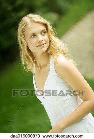 Young woman wearing white dress, looking over shoulder View Large Photo Image Stock Image - Young woman wearing white dress, looking over shoulder. Fotosearch