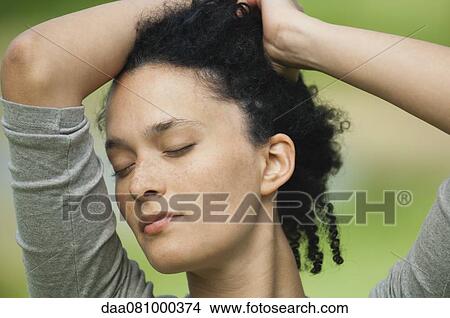 Young woman with eyes closed, hands in hair, portrait View Large Photo Image Picture - Young woman with eyes closed, hands in hair, portrait. Fotosearch
