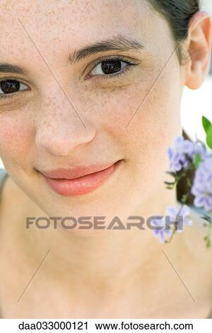 Stock Image - Young woman with flowers, close-up, portrait. Fotosearch