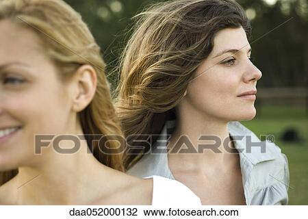 Stock Image - Young woman with friend outdoors. Fotosearch