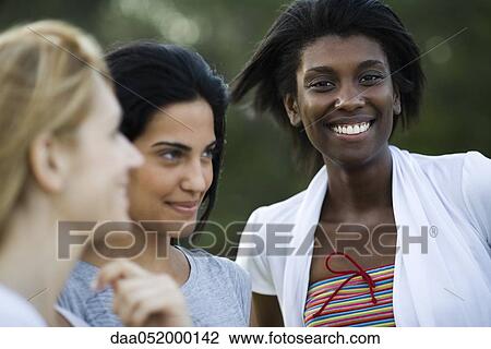 Young woman with friends, portrait View Large Photo Image Stock Image - Young woman with friends, portrait. Fotosearch