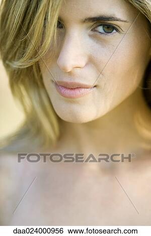 Young woman with hair in face, looking at camera, cropped portrait View Large Photo Image Stock Photograph - Young woman with hair in face, looking at camera, cropped portrait. Fotosearch