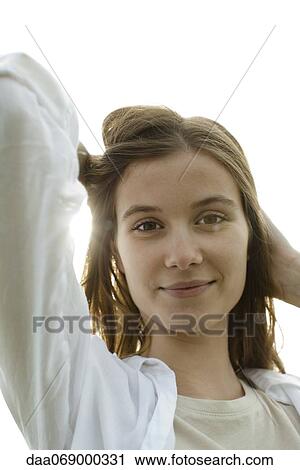 Young woman with hand in hair, portrait View Large Photo Image Stock Image - Young woman with hand in hair, portrait. Fotosearch