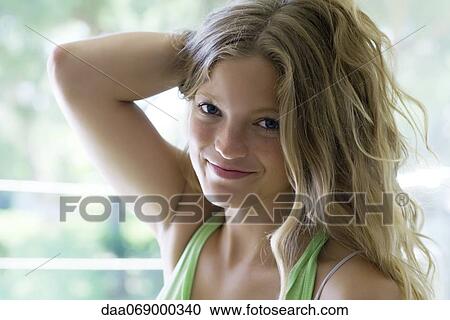 Young woman with hand in hair, portrait View Large Photo Image Stock Image - Young woman with hand in hair, portrait. Fotosearch