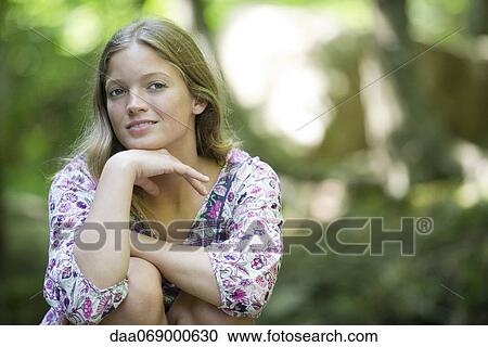 Young woman with hand under chin, portrait View Large Photo Image Stock Image - Young woman with hand under chin, portrait. Fotosearch