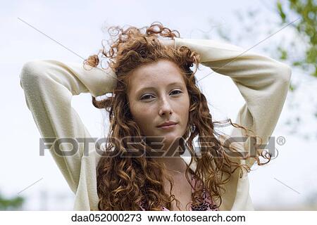 Young woman with hands on top of head, portrait View Large Photo Image Stock Image - Young woman with hands on top of head, portrait. Fotosearch