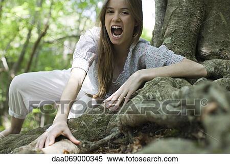 Young woman with mouth open climbing on roots of tree View Large Photo Image Stock Photography - Young woman with mouth open climbing on roots of tree. Fotosearch