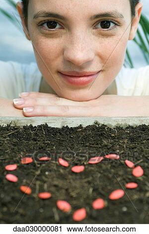 Young woman with seeds making heart shape View Large Photo Image Stock Image - Young woman with seeds making heart shape. Fotosearch