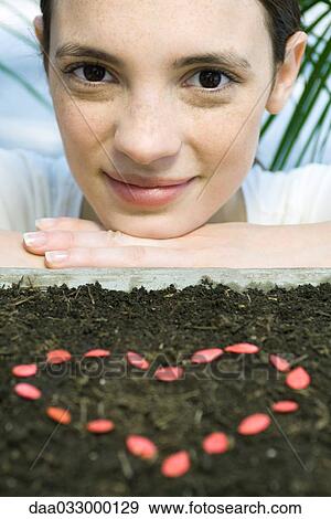 Young woman with seeds making heart shape View Large Photo Image Stock Photo - Young woman with seeds making heart shape. Fotosearch