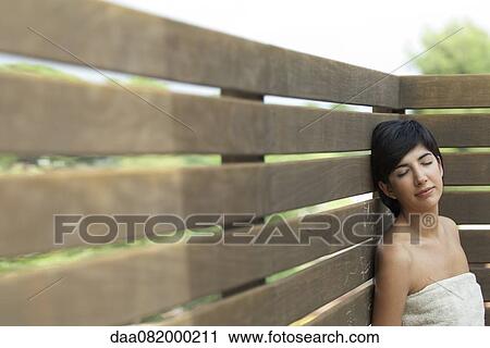 Young woman wrapped in towel relaxing outdoors with eyes closed View Large Photo Image Stock Image - Young woman wrapped in towel relaxing outdoors with eyes closed. Fotosearch