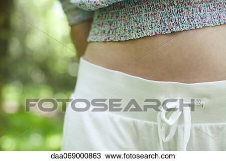 Stock Image - Young woman's abdomen, mid section. Fotosearch