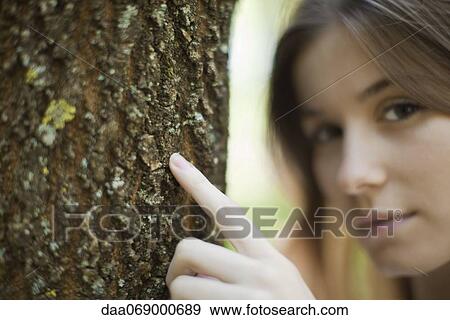 Young woman's finger touching tree trunk, cropped View Large Photo Image Stock Photo - Young woman's finger touching tree trunk, cropped. Fotosearch